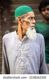 DHAKA, BANGLADESH - MAY 10, 2022: Portrait Of A Muslim Man With A Grey Long Beard And A Green Hat