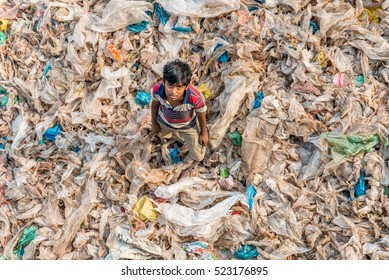 Dhaka, Bangladesh - November 26, 2016: little child stands in the garbage at Dhaka, Bangladesh
