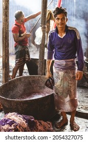 DHAKA, BANGLADESH - OCTOBER 03, 2021: Underaged Workers Or Child Labour In The Textile Industry Where They Are Dying The Garments And Textiles By Hand In A Bath Full Of Dying Chemicals 