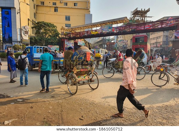 Dhaka,Bangladesh-11.24.2020: People with masks\
walking and crossing the streets of one of the most busiest\
junction of Dhaka, Mirpur 10. Busy streets of dhaka with the rise\
of corona\
again