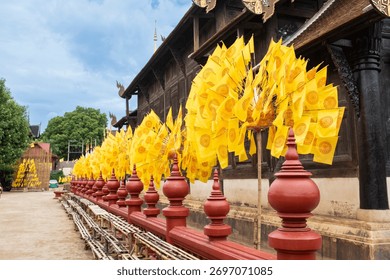 Dharmacakra yellow flags representing the wheel of Dhamma buddha on a buddhist temple in Chiang Rai, Thailand