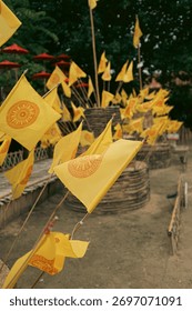 Dharmacakra yellow flags representing the wheel of Dhamma buddha on a buddhist temple in Chiang Rai, Thailand