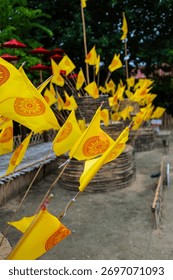 Dharmacakra yellow flags representing the wheel of Dhamma buddha on a buddhist temple in Chiang Rai, Thailand