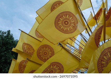 Dharmacakra yellow flags representing the wheel of Dhamma buddha on a buddhist temple in Chiang Rai, Thailand