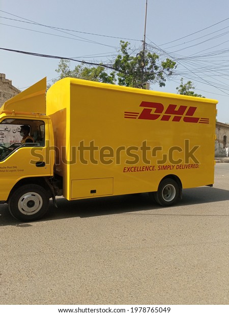 A DHL global courier service truck on a road   \
- Karachi Pakistan - May 2021