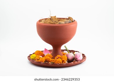 DHUNUCHI WITH COLOURFUL FLOWER ON CLAY THALI . ISOLATED ON WHITE WITH SELECTIVE FOCUS.