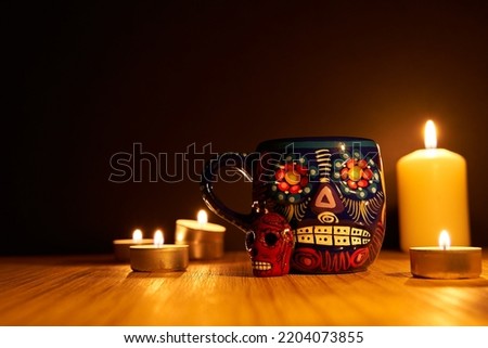 Dia de los muertos or day of the dead mexican sugar skulls with candles on wooden surface with black background