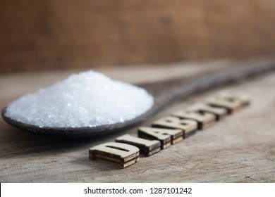 Diabetes block letters.Old wooden board background.Sugar pile.Old coconut timber spoon.