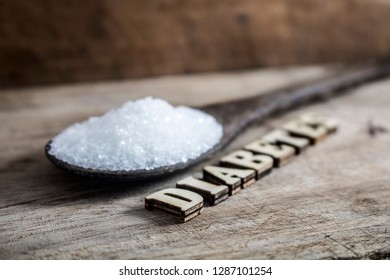 Diabetes block letters.Old wooden board background.Sugar pile.Old coconut timber spoon.2K19 Image.