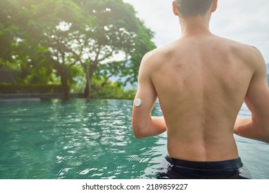 A Diabetes Patient In The Swimming Pool With A Waterproof CGM (Continuous Glucose Monitor) On His Arm