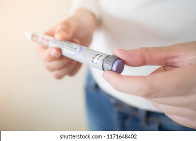 Diabetes Patient Turn Knob On End Of Insulin Pen And Dial Up Correct Insulin Dose For Injection. Scale Window On Pen Syringe Showing Number Of Units Dose. Medical Equipment Is Easy To Self Injection.