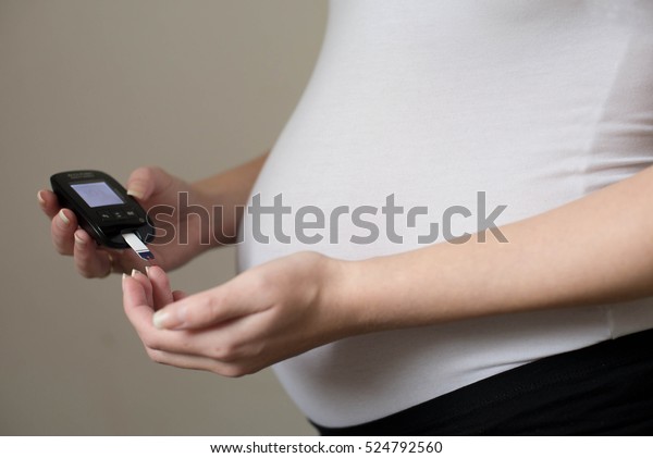 Diabetes test. Pregnant\
women checking sugar level with glucometer.Gestational\
diabetes.