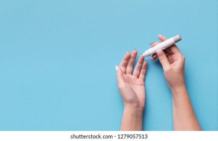 Diabetes Test. Woman Hands Checking Blood Sugar Level By Glucose Meter On Blue Background, Copy Space