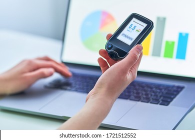 Diabetic Patient Using Remote Sensor And Computer For Control, Examining And Monitoring Glucose Blood Levels Graphs. Medical Technology In Diabetes Treatment, Healthcare