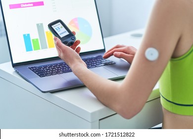 Diabetic Patient Using Remote Sensor And Computer For Online Monitoring And Examining Glucose Blood Levels Graphs. Medical Technology In Diabetes Treatment, Healthcare