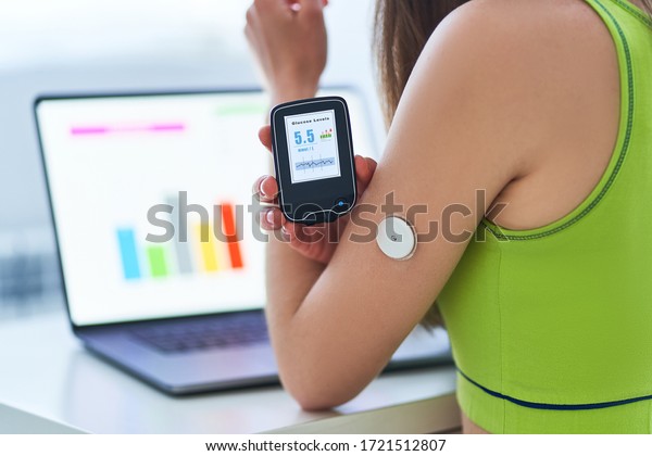 Diabetic patient using\
remote sensor and laptop for control and online monitoring glucose\
blood levels graphs. Medical technology in diabetes treatment and\
healthcare