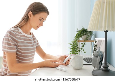 Diabetic Woman Checking Blood Sugar Level At Home