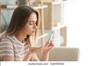 Diabetic Woman Checking Blood Sugar Level At Home