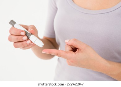 Diabetic Woman Using Blood Glucose Monitor On White Background