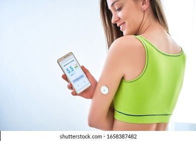 Diabetics Patient Checking Glucose Level With A Remote Sensor And Smartphone. Continuous Monitoring Glucose Levels Without Blood Using Digital Glucose Meter. Health Care 