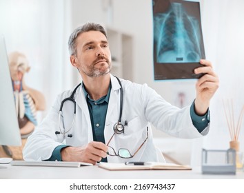 Diagnosing and treating the injury. Shot of a mature doctor analysing x-ray scans in a medical office. - Powered by Shutterstock