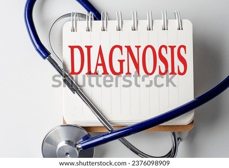 DIAGNOSIS word on a notebook with medical equipment on background