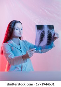 Diagnostic Radiology. Rib Study. Traumatology Examination. Fracture Diagnosis. Confident Female Surgeon Doctor Checking Chest Skeleton X-ray Scan On Pink Neon Background.