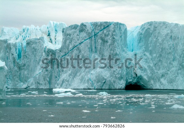 Diagonal blue ice line showing\
high oxygen content, in a vast wall of blue and white ice, calving\
from a glacier in western Greenland, into the freezing Arctic\
Ocean.