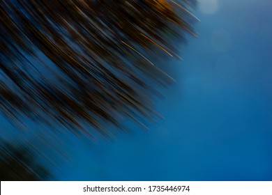 Diagonal dark green and yellow light streaks on deep blue sky with soft hexagonal lens flares - abstract motion blurred background, texture - Powered by Shutterstock