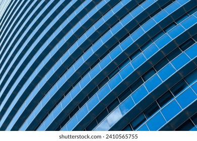 Diagonal intersection of blue glass skyscraper with reflections and white building lines