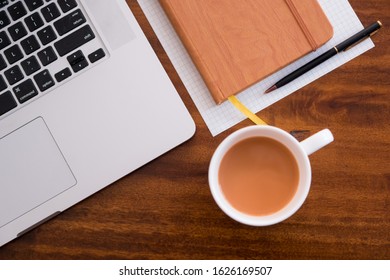 Diagonal Layflat Of Workspace. Self Starter, Meeting Minutes, Note Taking And Working As A Student Or At A Cafe/ Coffee Shop On Wooden Table With Cup Of Coffee/tea. Mobile Office, Work Anywhere