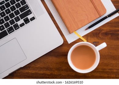 Diagonal Layflat Of Workspace. Self Starter, Meeting Minutes, Note Taking And Working As A Student Or At A Cafe/ Coffee Shop On Wooden Table With Cup Of Coffee/tea. Mobile Office, Work Anywhere