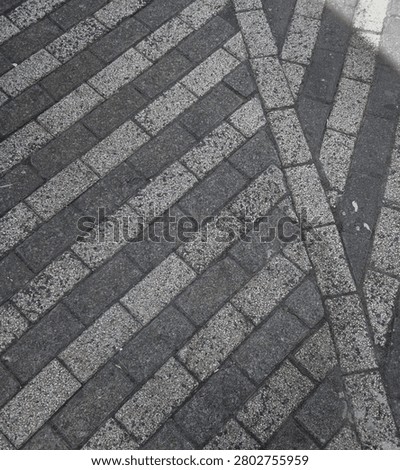 Diagonal Pattern of Gray and White Interlocking Brick Pavement Texture Background