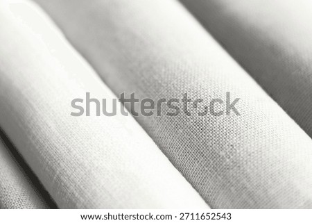 Diagonal textural background of cloud white dancer natural linen fabric, rolled up. Demonstrating color, trend 2026 year.