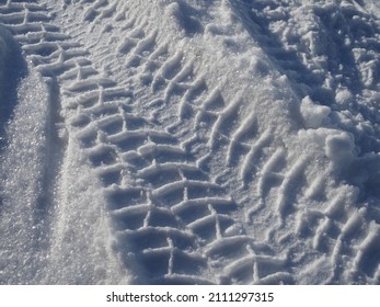 Diagonal track of car tire in pure white snow.