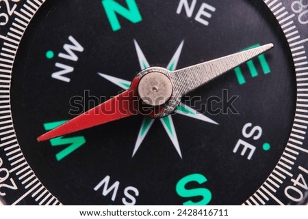 Dial compass in closeup, arrow indicates direction west