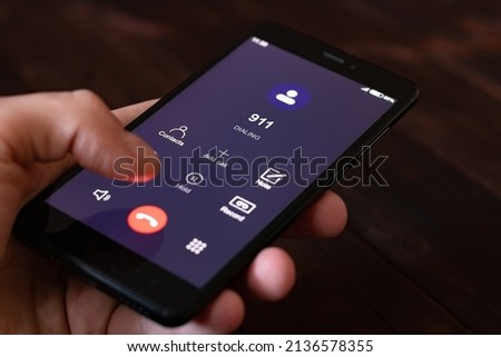 Dialing 911, call 911. Emergency concept: man using a digital phone with emergency call on the screen. All screen graphics are made up