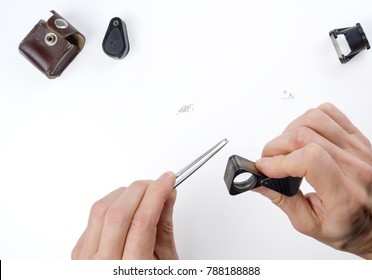 A diamond appraisal. Tools for evaluation of diamonds (magnifier, measuring loupe, tweezers) isolated on white background.