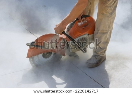 Diamond blade saws are used by construction workers to cut concrete sidewalk
