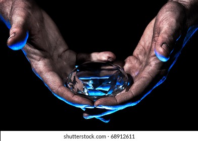 Diamond In Dirty Hands - Dirty Male Hands Hold Diamond Against Black Background - Blue Lit From Underside