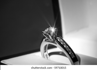 A diamond engagement ring in a box with glint/reflection.