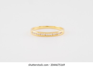 A Diamond And Gold Wedding Or Eternity Band On A White Background