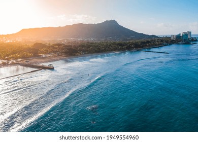 Diamond Head Mountain and Waikiki Queens Beach during sunrise. Palms on the beach with light effect. Oahu Island, Hawaii