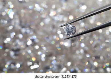 Diamond Held By Tweezers Close Up. More Diamonds Out Of Focus In Background.