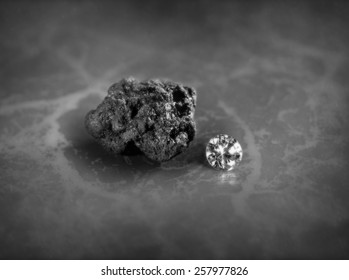 A Diamond And A Piece Of Coal On A Slate Background