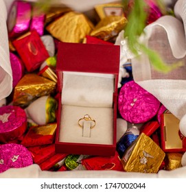 Diamond proposal ring in red box with flowers and sweets