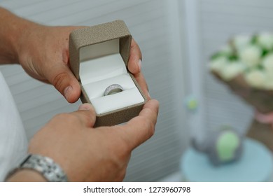 Diamond ring in the hands of a man. On the background of flowers - Shutterstock ID 1273960798