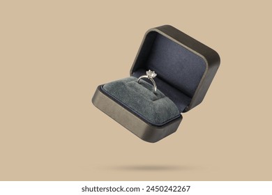Diamond ring in jewelry gift box floated on brown background