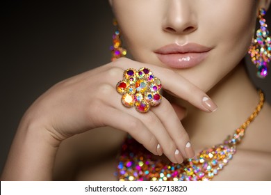 Diamond ring on the hand of a beautiful woman. Brilliant.  Antique old vintage earrings and ring. Jewelry on girl finger with lux manicure