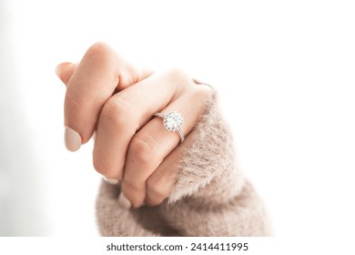 Diamond Ring on Woman's Closed Hand, wearing sweater - Powered by Shutterstock